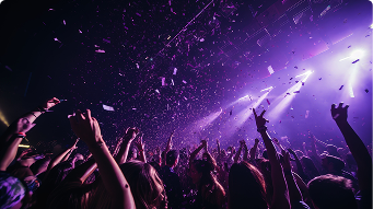 Público disfrutando de una fiesta nocturna con luces y confeti. Traslados seguros para eventos y vida nocturna